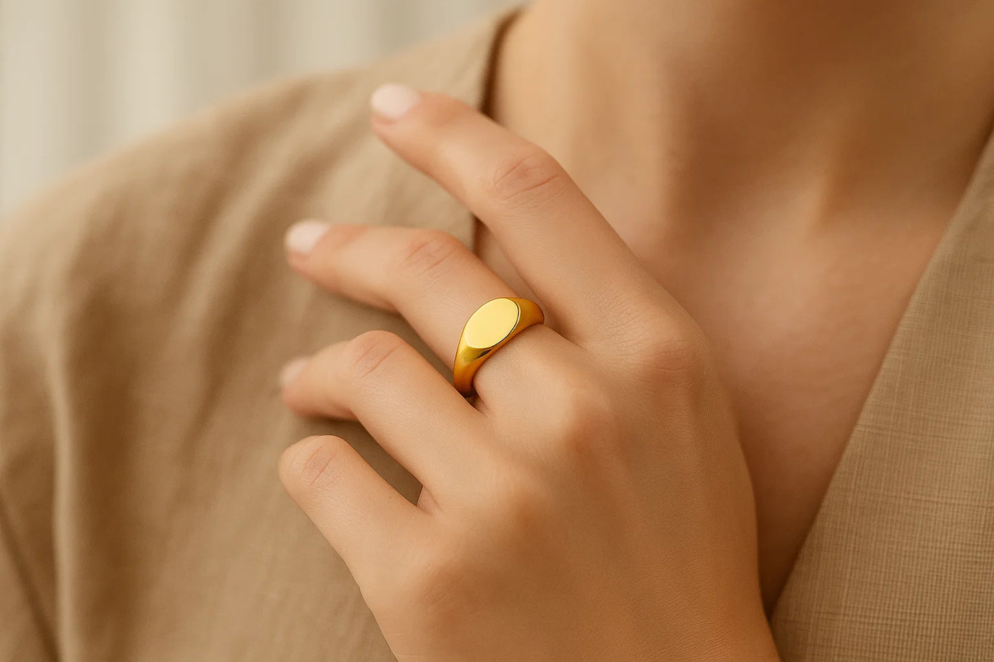 Gold ring on a hand with a neutral background