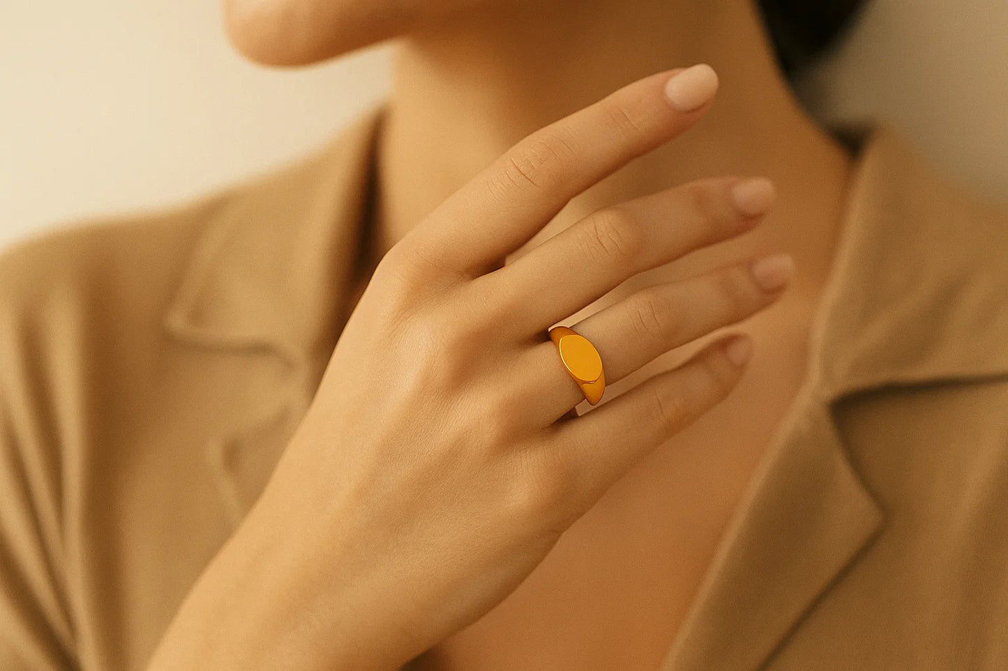 Close-up of a hand wearing a yellow ring with a neutral background